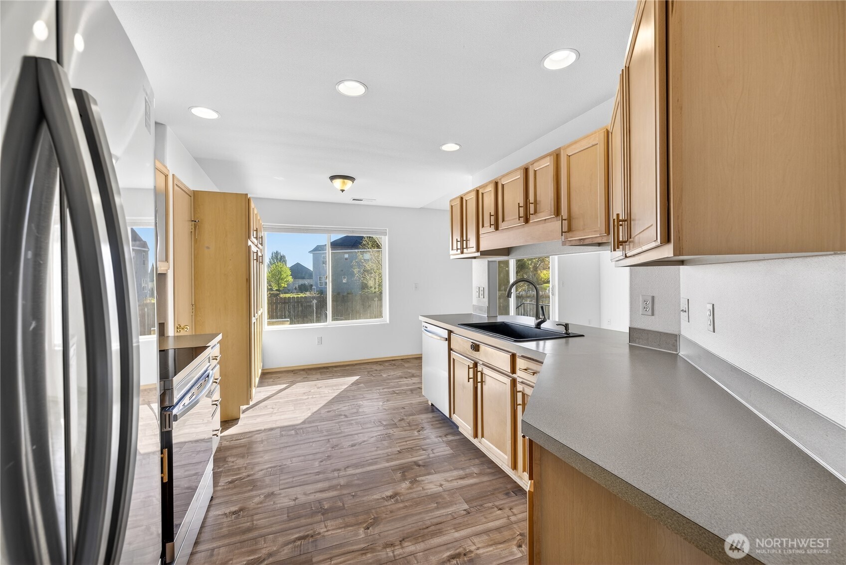 4607 Santa Fe Lane Pasco, WA 99301 - Photo 9 of 28 a kitchen with stainless steel appliances granite countertop a refrigerator a sink dishwasher a stove and white countertops with wooden floor