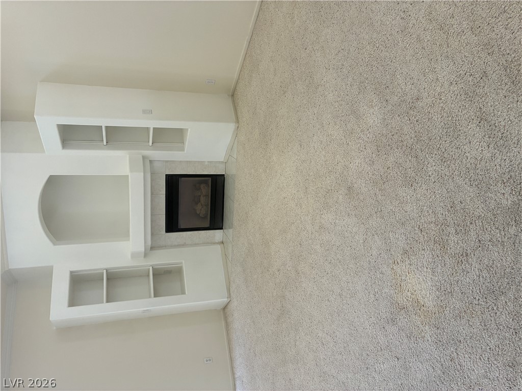5272 Island Chain Road Las Vegas, NV 89118 - Photo 18 of 39 A cozy fireplace hearth with built-in shelving offers warmth and storage. Vaulted ceilings provide tons of natural light.