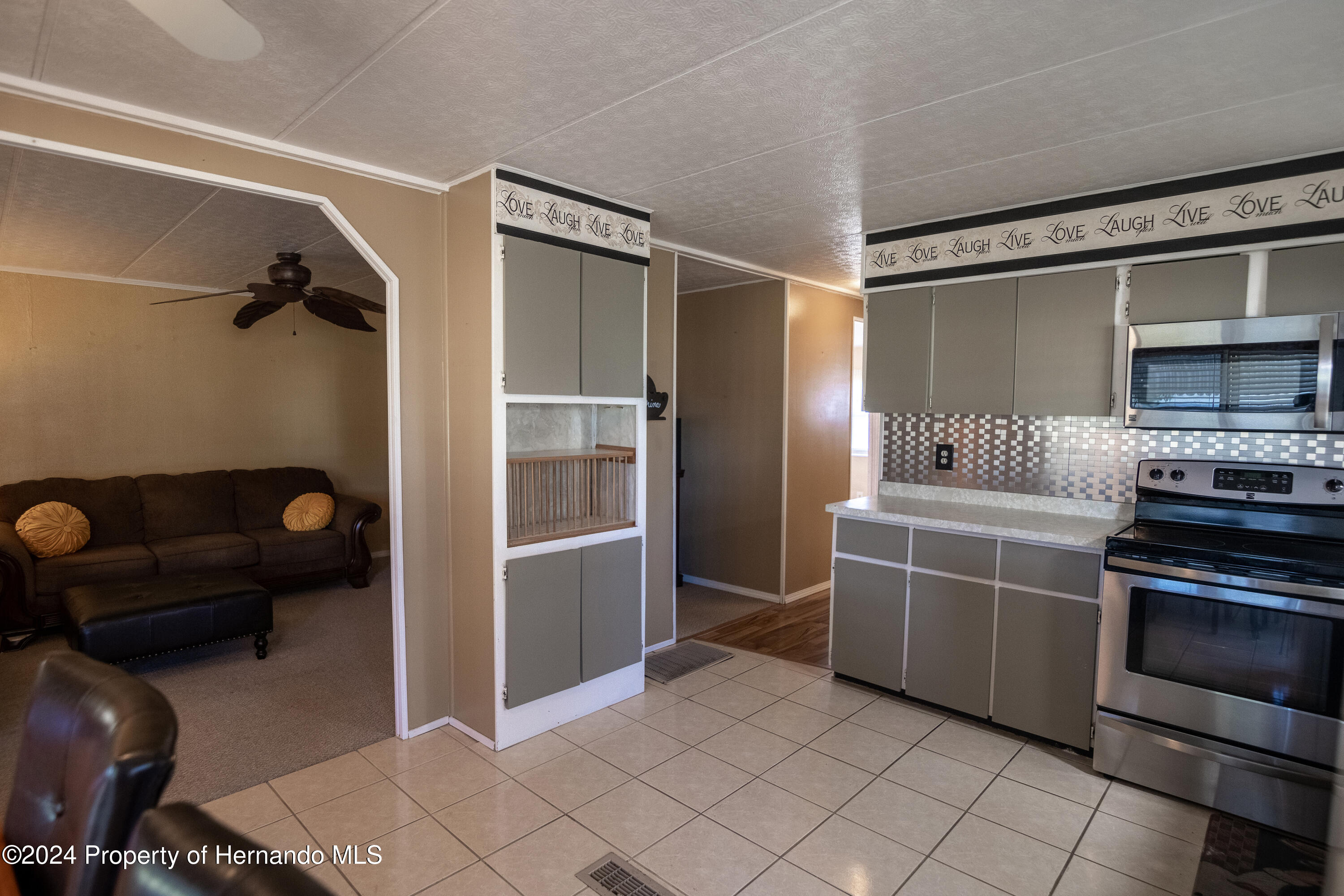 7526 Highpoint Boulevard Brooksville, FL 34613 - Photo 11 of 30 a kitchen with granite countertop a refrigerator and a stove