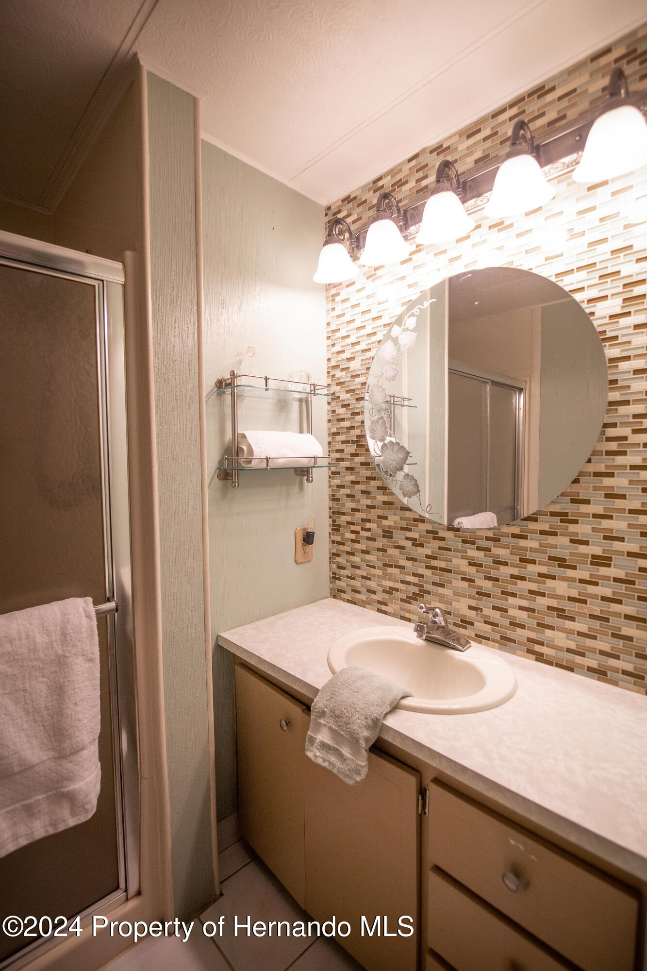 7526 Highpoint Boulevard Brooksville, FL 34613 - Photo 17 of 30 a bathroom with a sink and a mirror