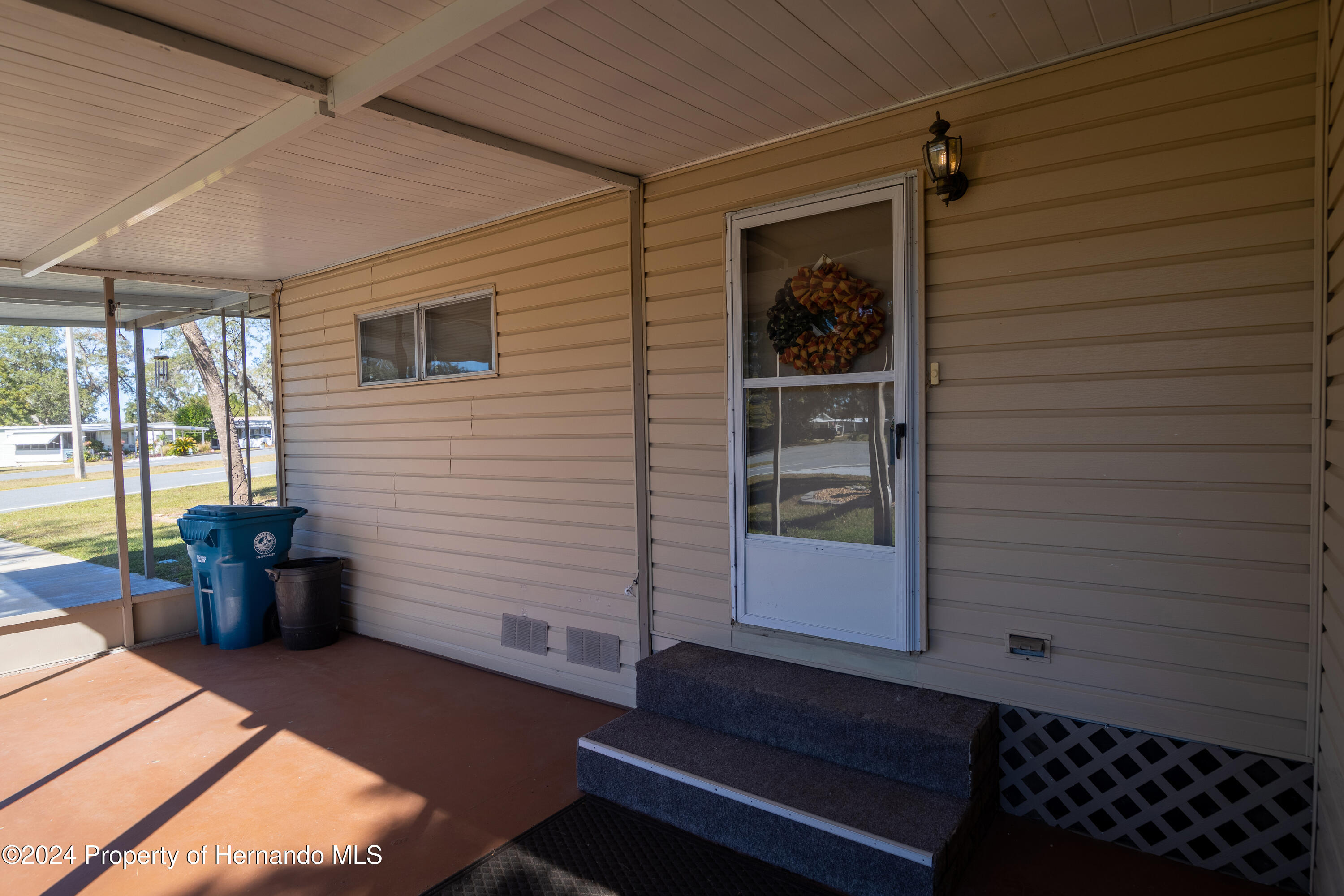 7526 Highpoint Boulevard Brooksville, FL 34613 - Photo 27 of 30 a view of a patio with table and chairs and potted plants