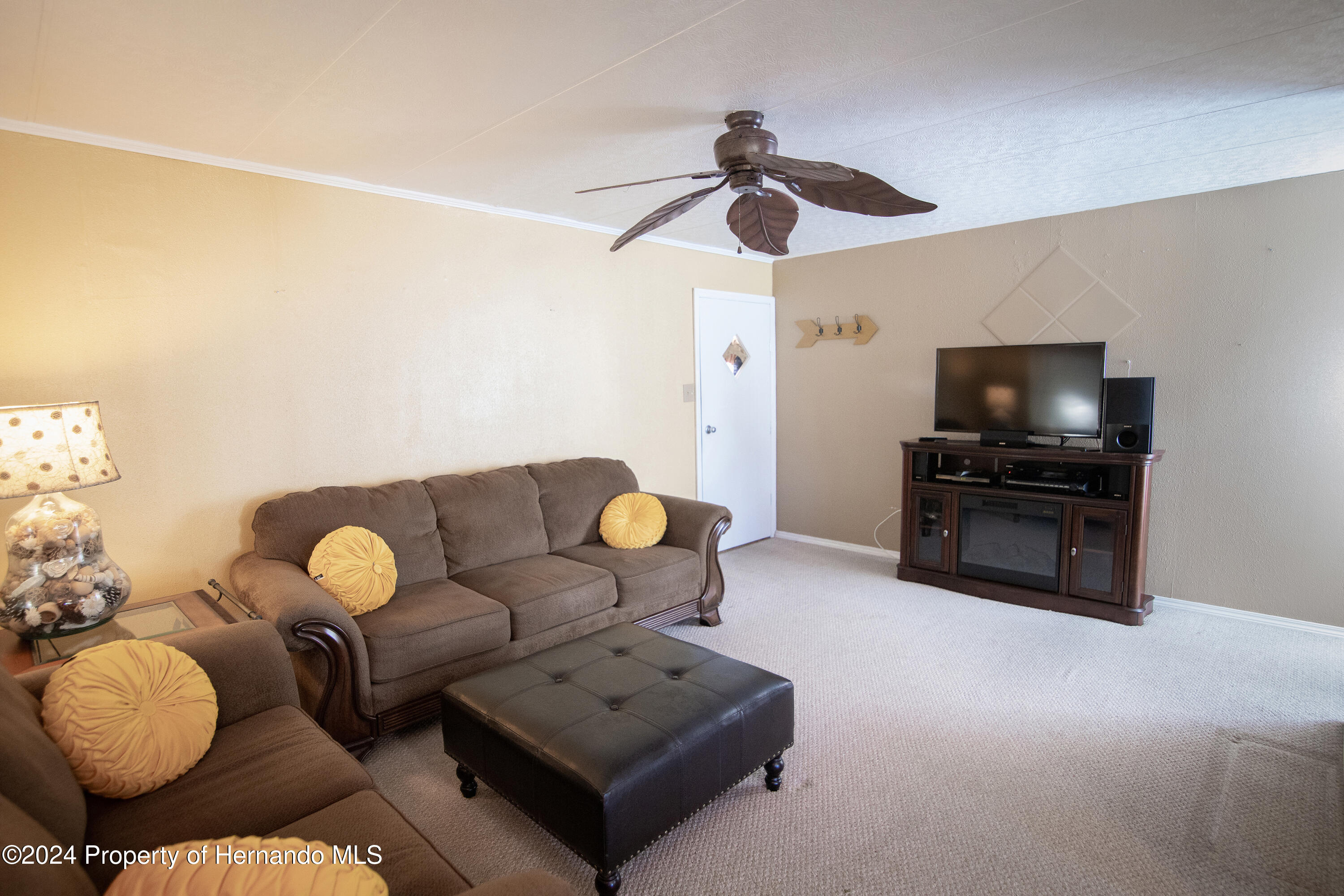 7526 Highpoint Boulevard Brooksville, FL 34613 - Photo 8 of 30 a living room with furniture and a flat screen tv