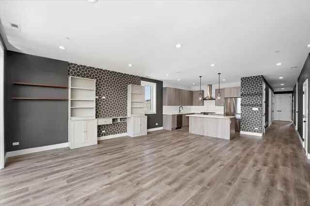 a large white kitchen with kitchen island a sink stainless steel appliances and cabinets