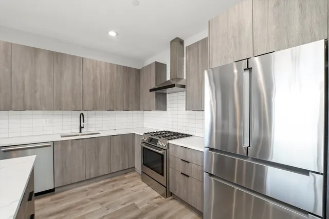 a kitchen with stainless steel appliances granite countertop a refrigerator and a sink