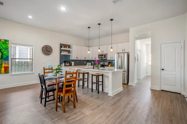 a kitchen with a table chairs refrigerator and microwave