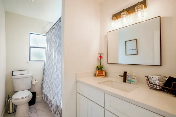 a bathroom with a toilet sink and mirror