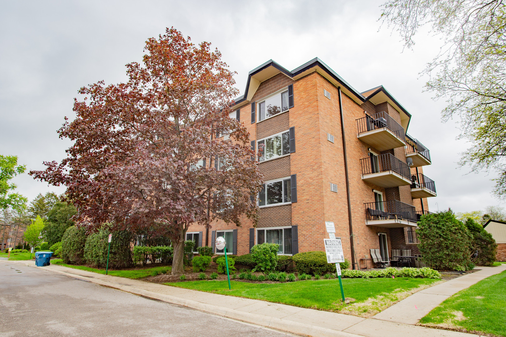 1217 South Old Wilke Road, Unit 201 Rolling Meadows, IL 60005 - Photo 2 of 26 a view of a brick building next to a yard