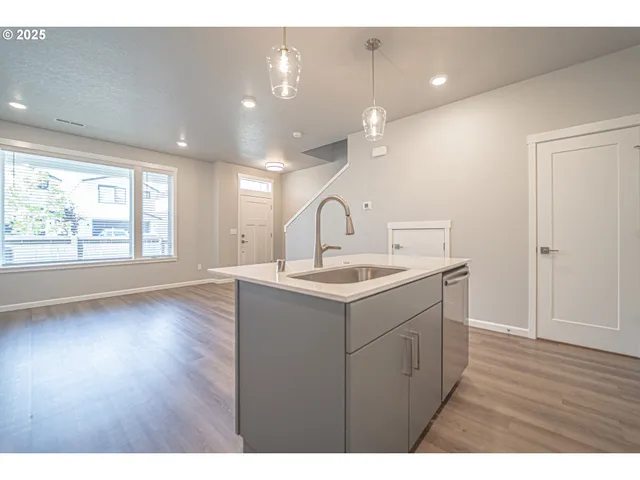 a kitchen with kitchen island a sink stainless steel appliances and cabinets