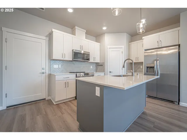 a kitchen with a sink wooden floor cabinets and appliances