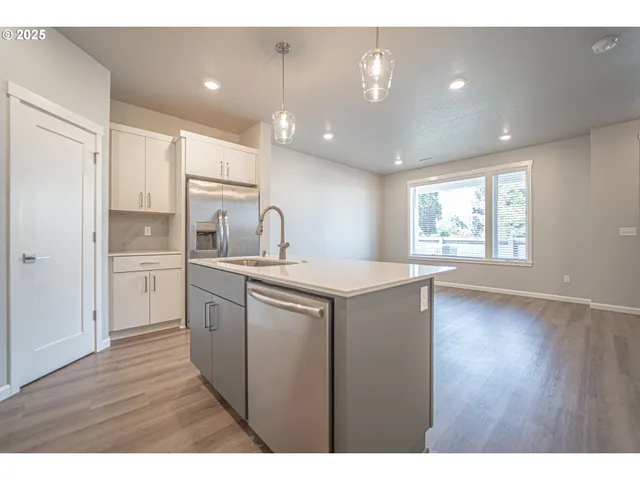 a kitchen with a sink cabinets and wooden floor