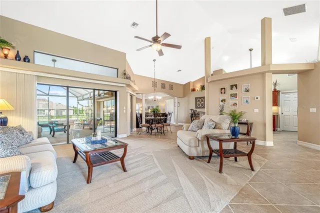 a living room with furniture kitchen view and a chandelier