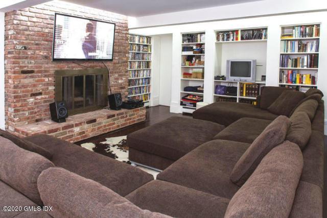424 Cognewaugh Road Cos Cob, CT 06807 - Photo 16 of 27 a living room with furniture a fireplace and a flat screen tv