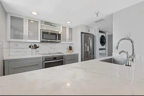 a kitchen with stainless steel appliances granite countertop a sink a stove a microwave and a refrigerator