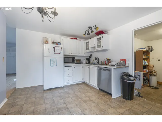 a kitchen that has a lot of cabinets a sink and appliances