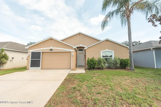 a front view of house with yard and garage
