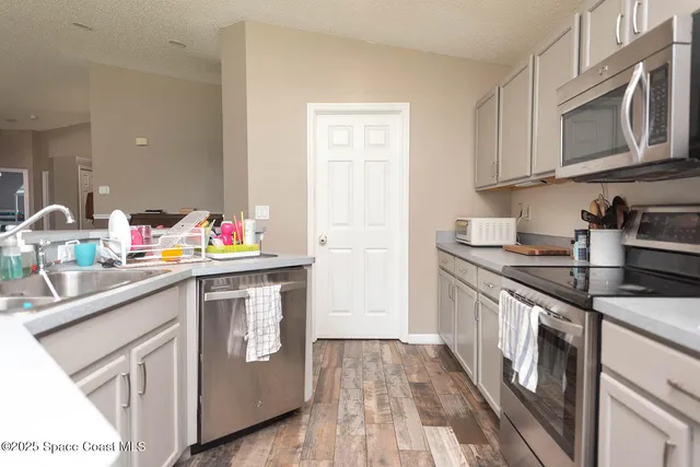 a kitchen with stainless steel appliances granite countertop a sink stove and cabinets