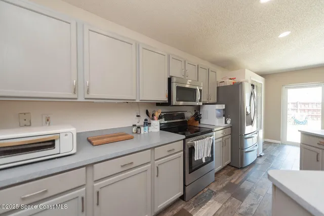 a kitchen with stainless steel appliances granite countertop a refrigerator sink and stove top oven