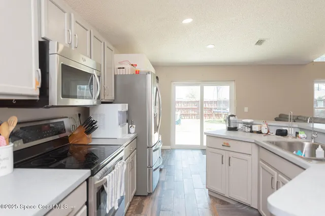 a kitchen with stainless steel appliances a sink stove and cabinets