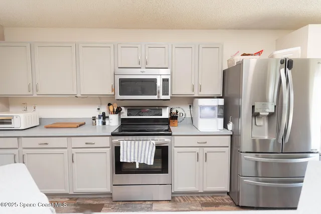 a kitchen with white cabinets and stainless steel appliances