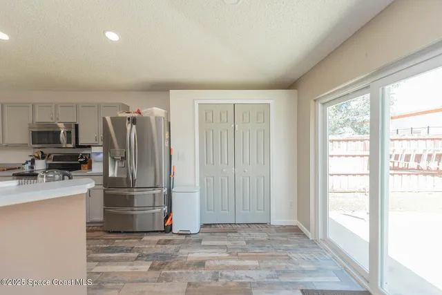 a kitchen with a refrigerator and a stove top oven