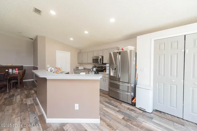 a kitchen with stainless steel appliances a refrigerator and a stove top oven