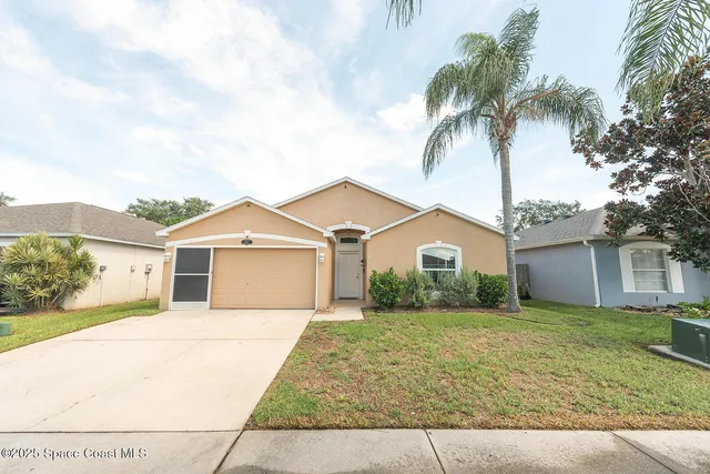 a front view of a house with a garden and trees
