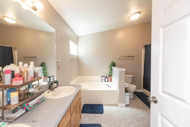 a spacious bathroom with a tub sink and mirror