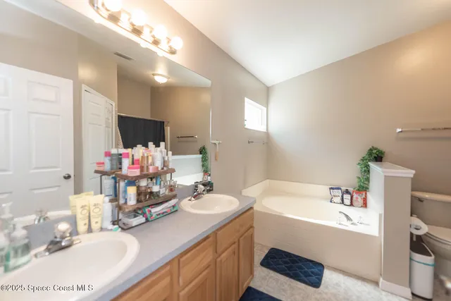 a bathroom with a granite countertop sink mirror and bathtub