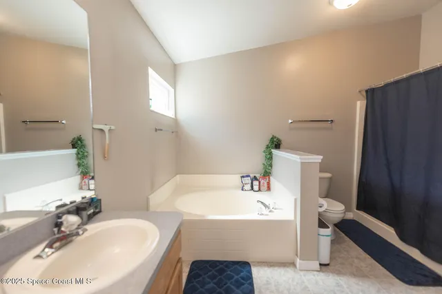 a bathroom with a tub sink and mirror