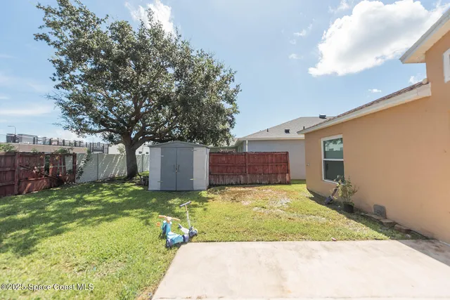 a view of a yard with a house and a large tree