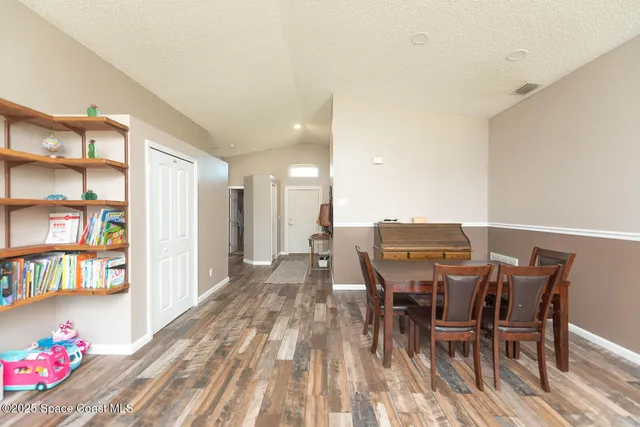 a view of a dining room with furniture and a book shelf