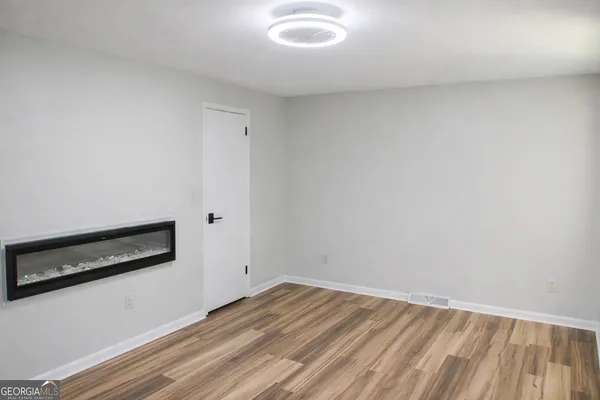 a view of a room with wooden floor and white walls
