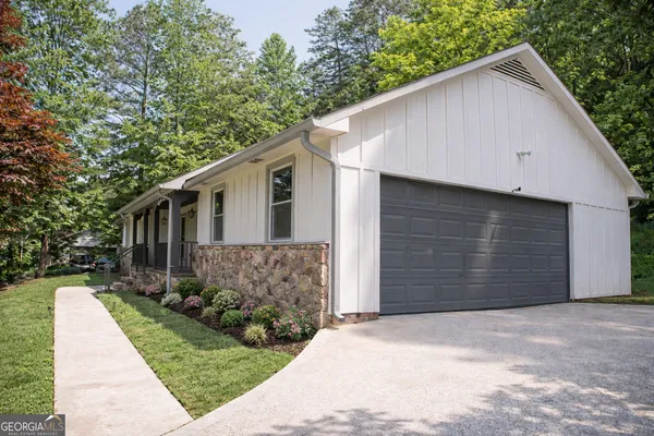 a view of house with a yard and garage