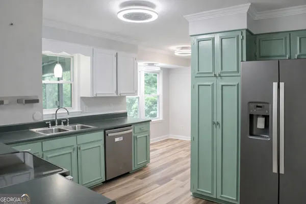 a kitchen with stainless steel appliances granite countertop a refrigerator and a sink