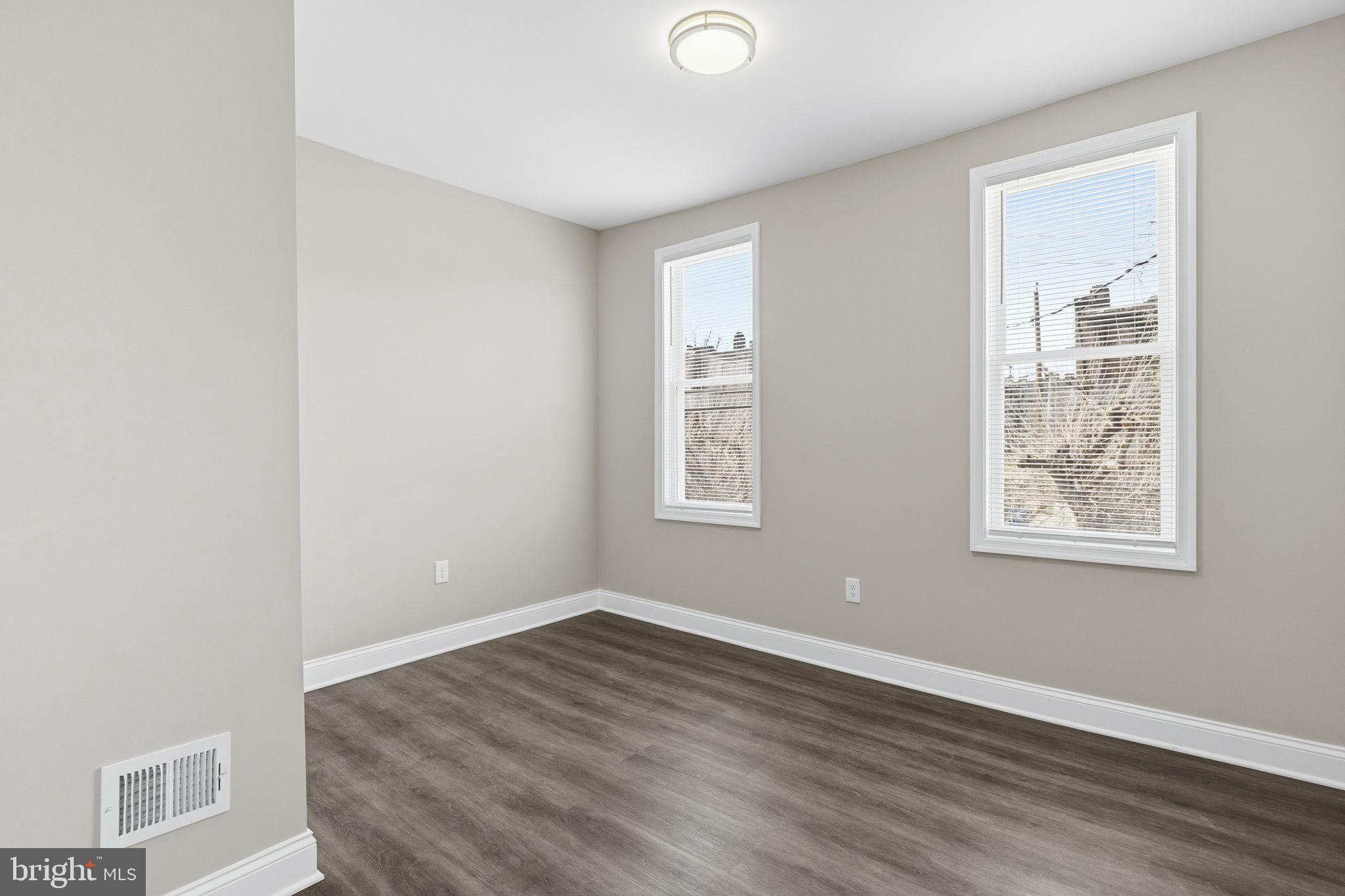 1200 North Dukeland Street Baltimore, MD 21216 - Photo 11 of 17 an empty room with wooden floor and windows