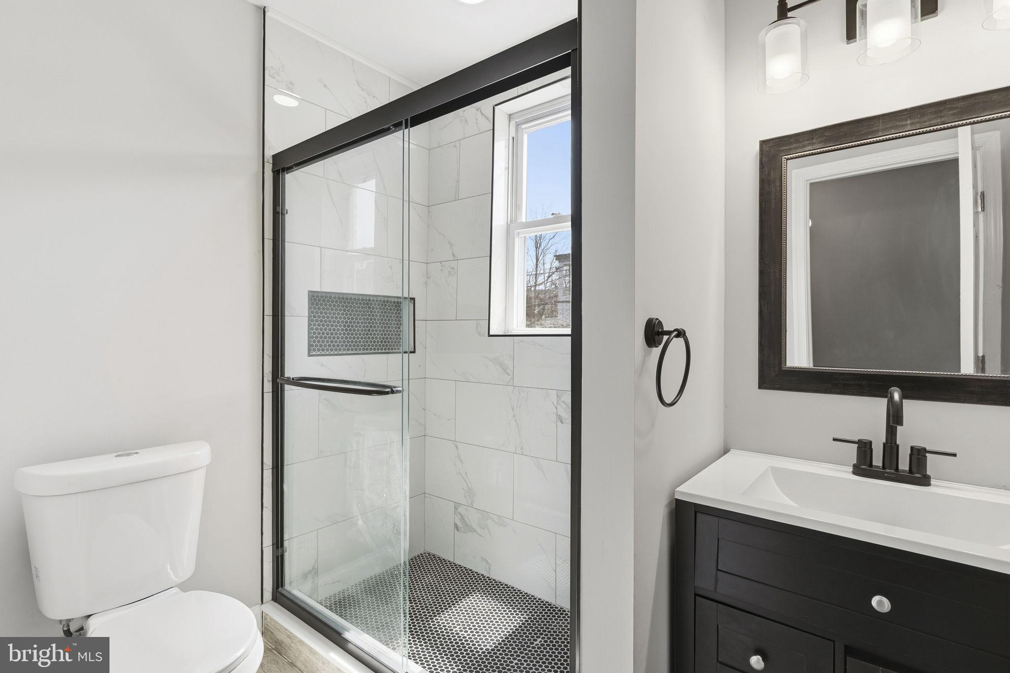 1200 North Dukeland Street Baltimore, MD 21216 - Photo 13 of 17 a bathroom with a sink a toilet and shower