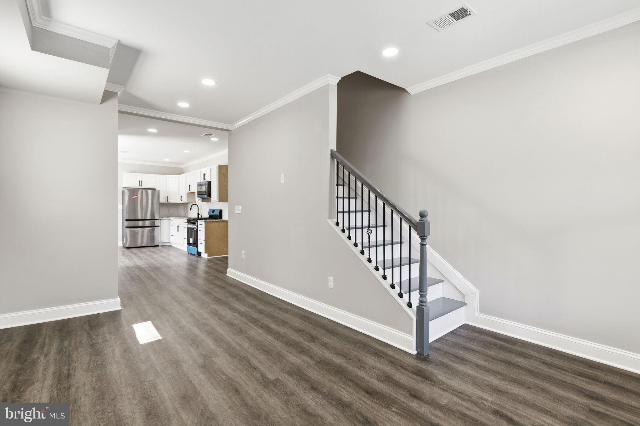 1200 North Dukeland Street Baltimore, MD 21216 - Photo 2 of 17 a view of a hallway with wooden floor and a living room
