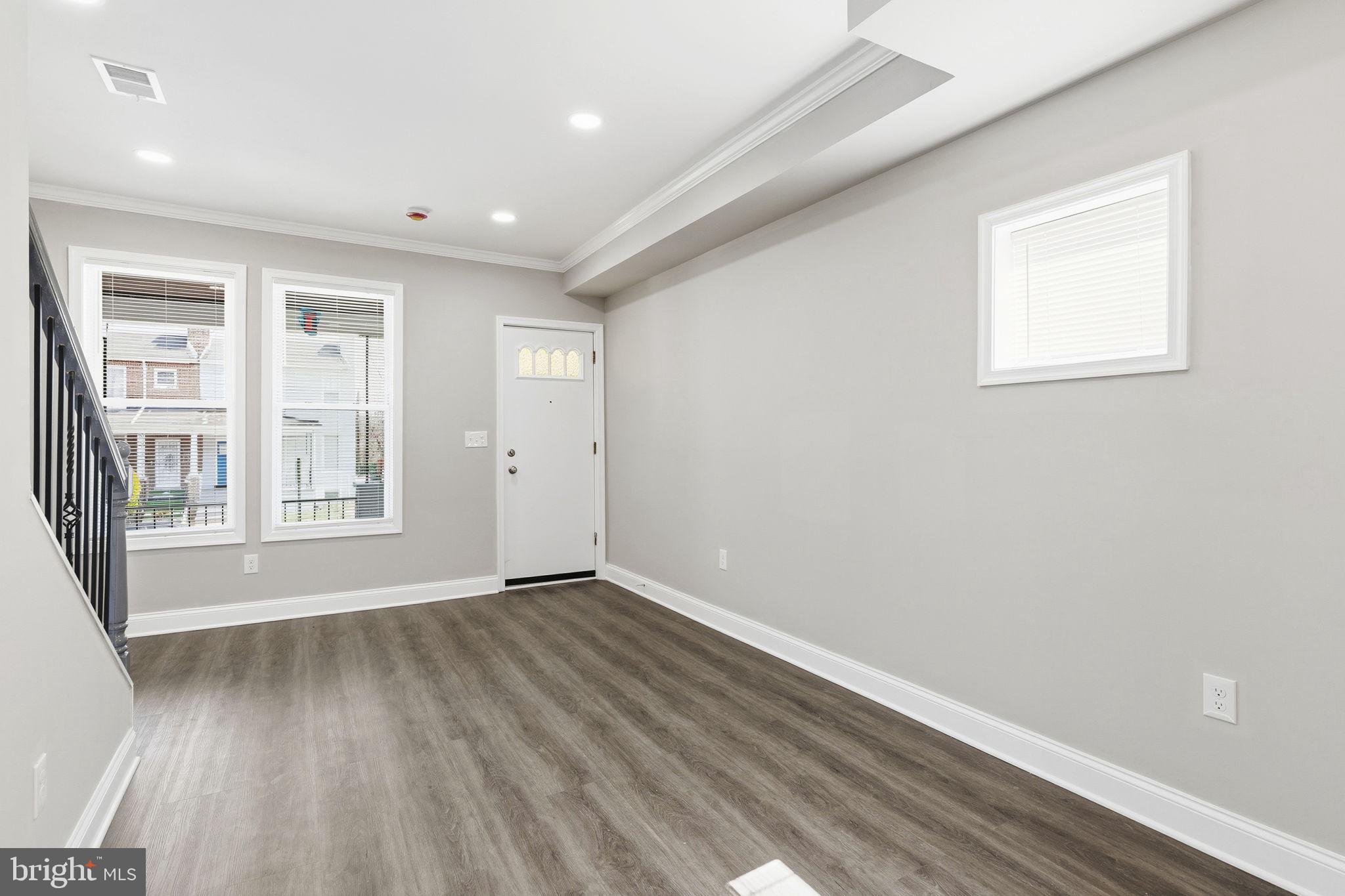 1200 North Dukeland Street Baltimore, MD 21216 - Photo 3 of 17 a view of an empty room with wooden floor and a window
