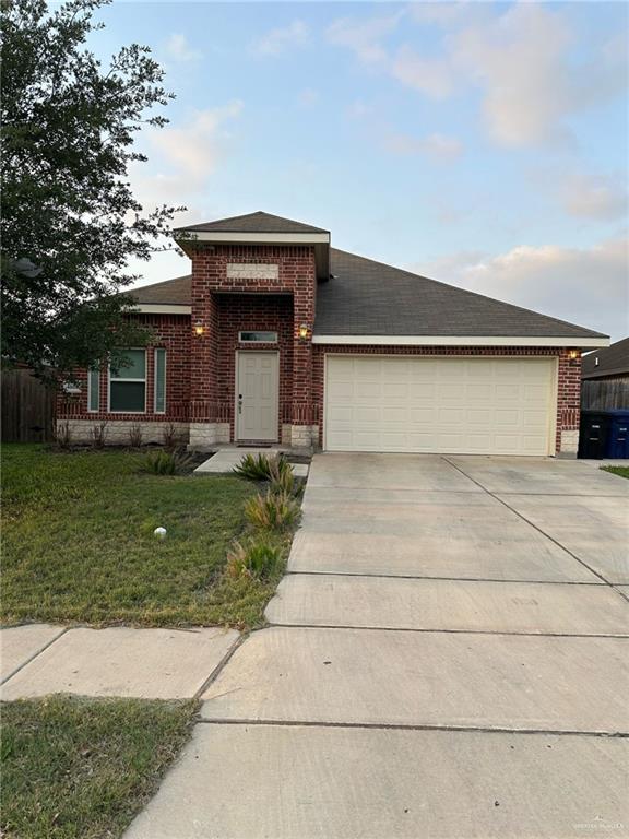 4608 Robin Avenue McAllen, TX 78504 - Photo 1 of 12 Brick facade home featuring an attached two-car garage, a covered front entry, and a concrete driveway