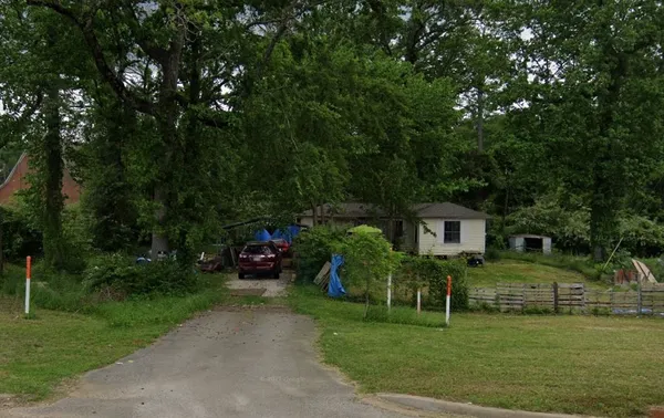 a view of a house with a big yard and large trees
