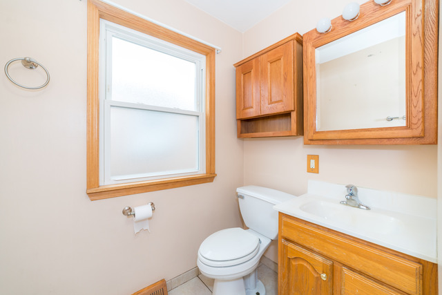3648 West 81st Street Chicago, IL 60652 - Photo 12 of 17 a bathroom with a toilet a sink and a window