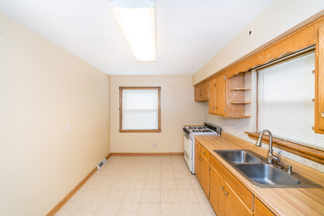 3648 West 81st Street Chicago, IL 60652 - Photo 4 of 17 a kitchen with a sink a counter top space and cabinets