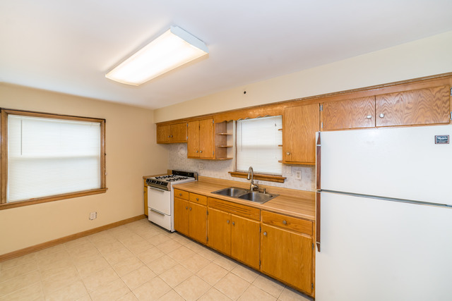 3648 West 81st Street Chicago, IL 60652 - Photo 5 of 17 a kitchen with a sink a refrigerator and cabinets