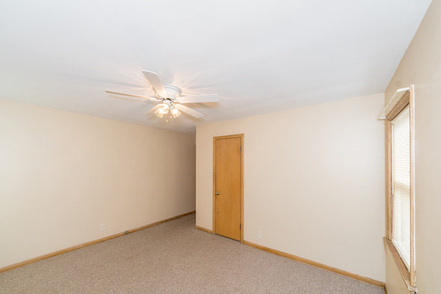 3648 West 81st Street Chicago, IL 60652 - Photo 10 of 17 an empty room with a ceiling fan and a window