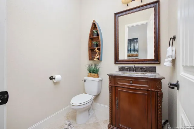 a bathroom with a toilet a sink and mirror