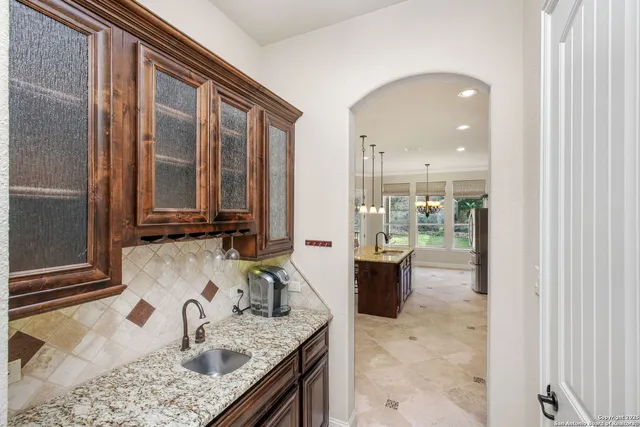a kitchen with a granite countertop sink and a refrigerator