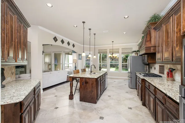 a kitchen with stainless steel appliances granite countertop a sink and a refrigerator