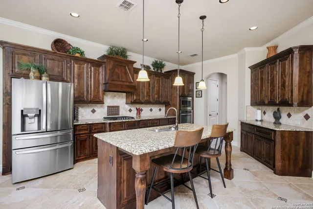 a kitchen with granite countertop a table chairs stainless steel appliances and cabinets