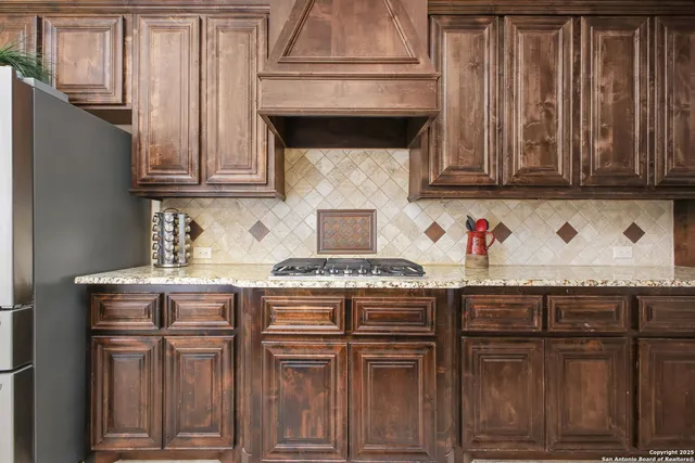 a kitchen with granite countertop a stove top oven cabinetry and granite counter tops