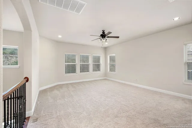 a room with furniture a chandelier a rug and a ceiling fan